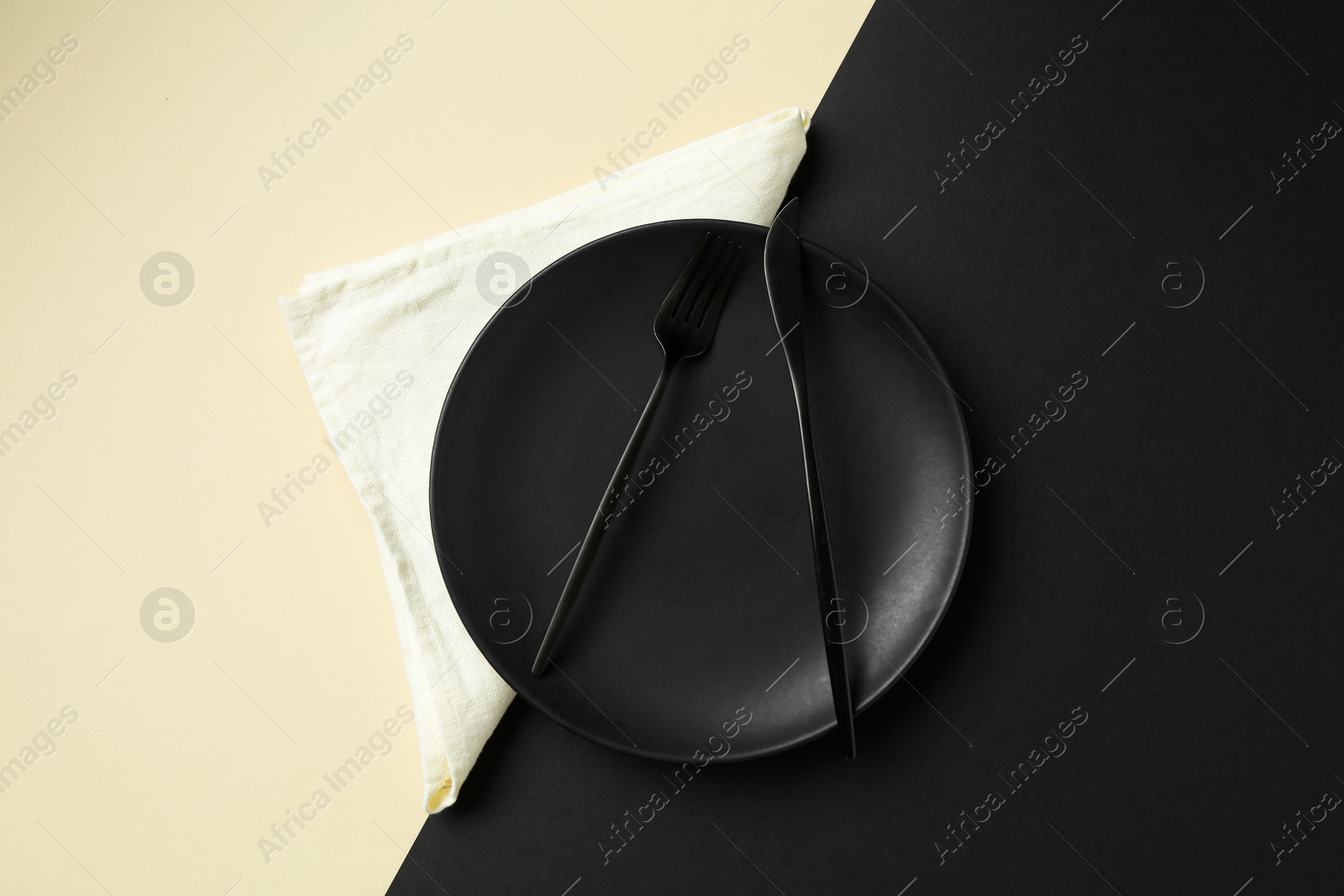 Stylish plate, cutlery and napkin on color background, top view Photo of Stylish plate, cutlery and napkin on color background, top view