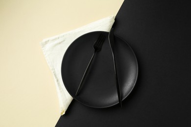 Photo of Stylish plate, cutlery and napkin on color background, top view