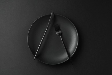 Photo of Stylish plate and cutlery on black background, top view