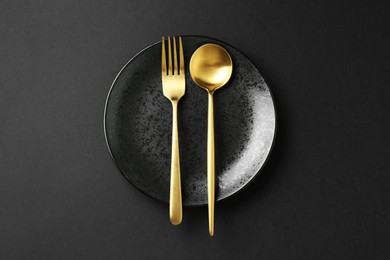 Photo of Stylish plate and cutlery on black background, top view