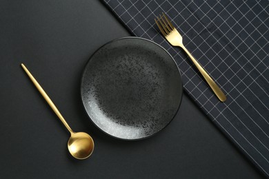 Photo of Stylish plate, cutlery and runner on black background, flat lay