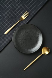 Photo of Stylish plate, cutlery and runner on black background, flat lay