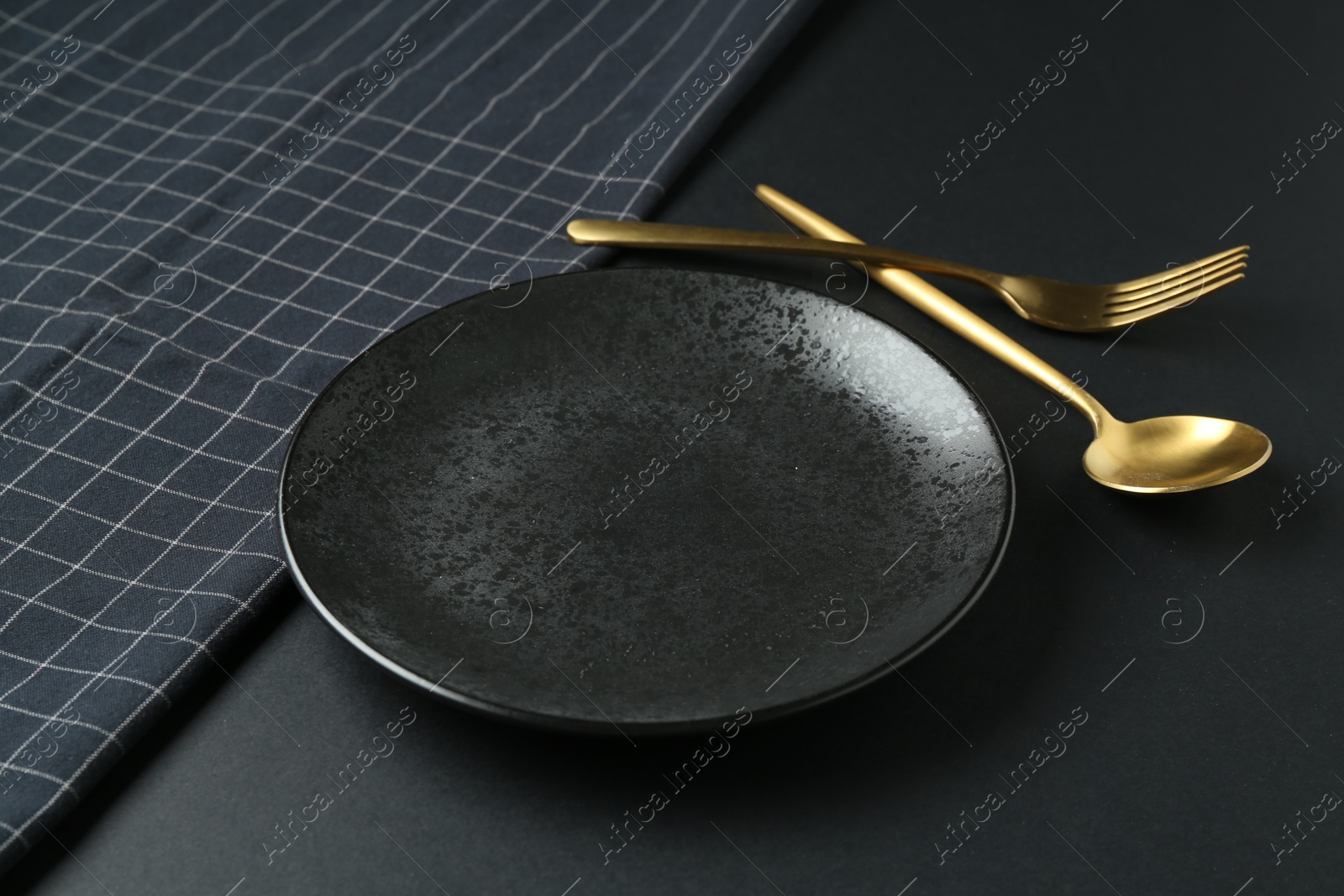 Photo of Stylish plate, cutlery and runner on black background, closeup