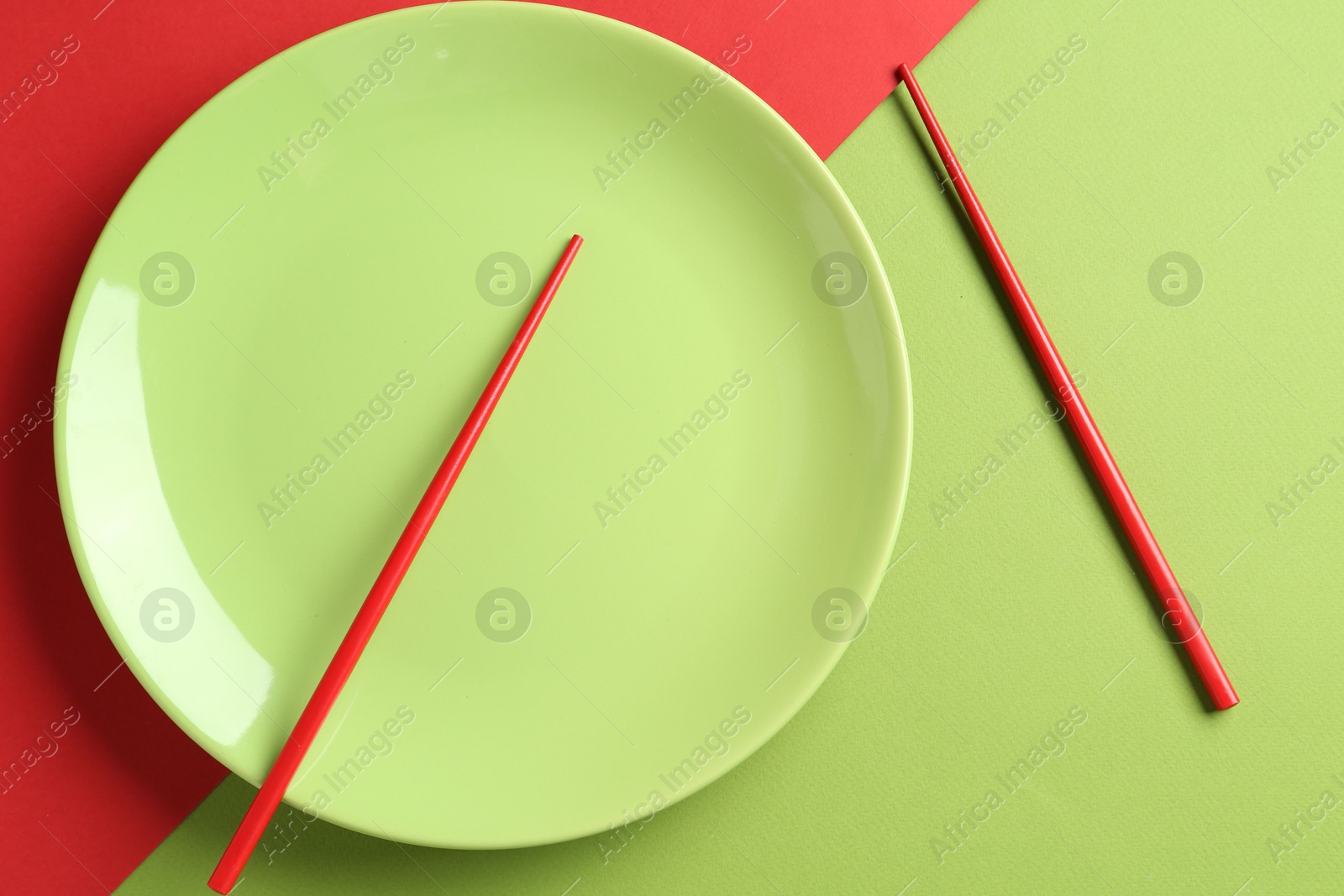Stylish plate and chopsticks on color background, flat lay Photo of Stylish plate and chopsticks on color background, flat lay