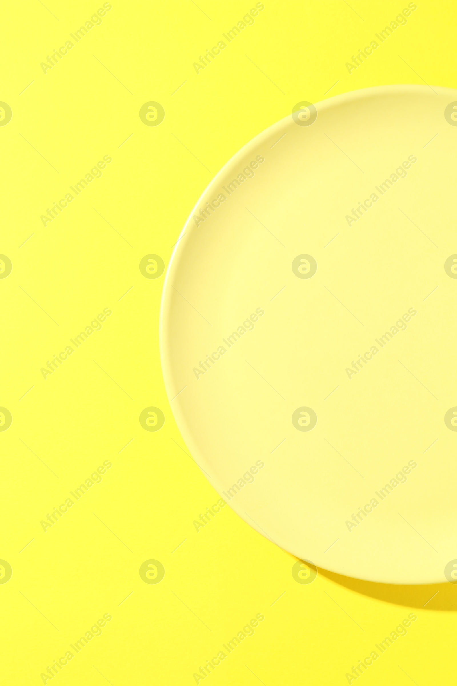 One stylish plate on yellow background, top view Photo of One stylish plate on yellow background, top view