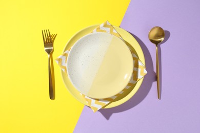 Photo of Stylish plates, cutlery and napkin on color background, flat lay