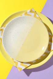 Photo of Stylish plates and napkin on color background, top view