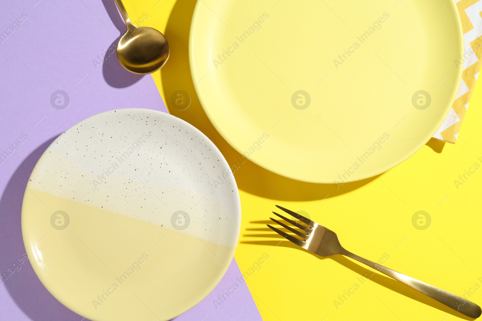 Stylish plates, cutlery and napkin on color background, flat lay Photo of Stylish plates, cutlery and napkin on color background, flat lay