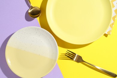 Photo of Stylish plates, cutlery and napkin on color background, flat lay