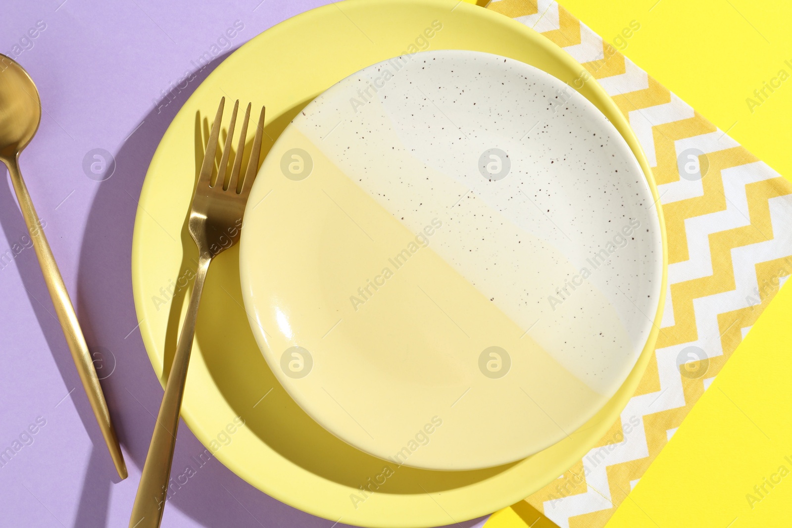 Stylish plates, cutlery and napkin on color background, flat lay Photo of Stylish plates, cutlery and napkin on color background, flat lay