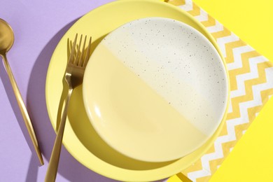 Photo of Stylish plates, cutlery and napkin on color background, flat lay