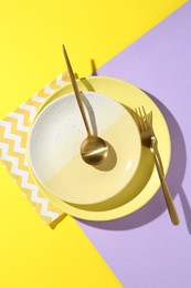 Photo of Stylish plates, cutlery and napkin on color background, flat lay