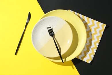 Photo of Stylish plates, cutlery and napkin on color background, flat lay