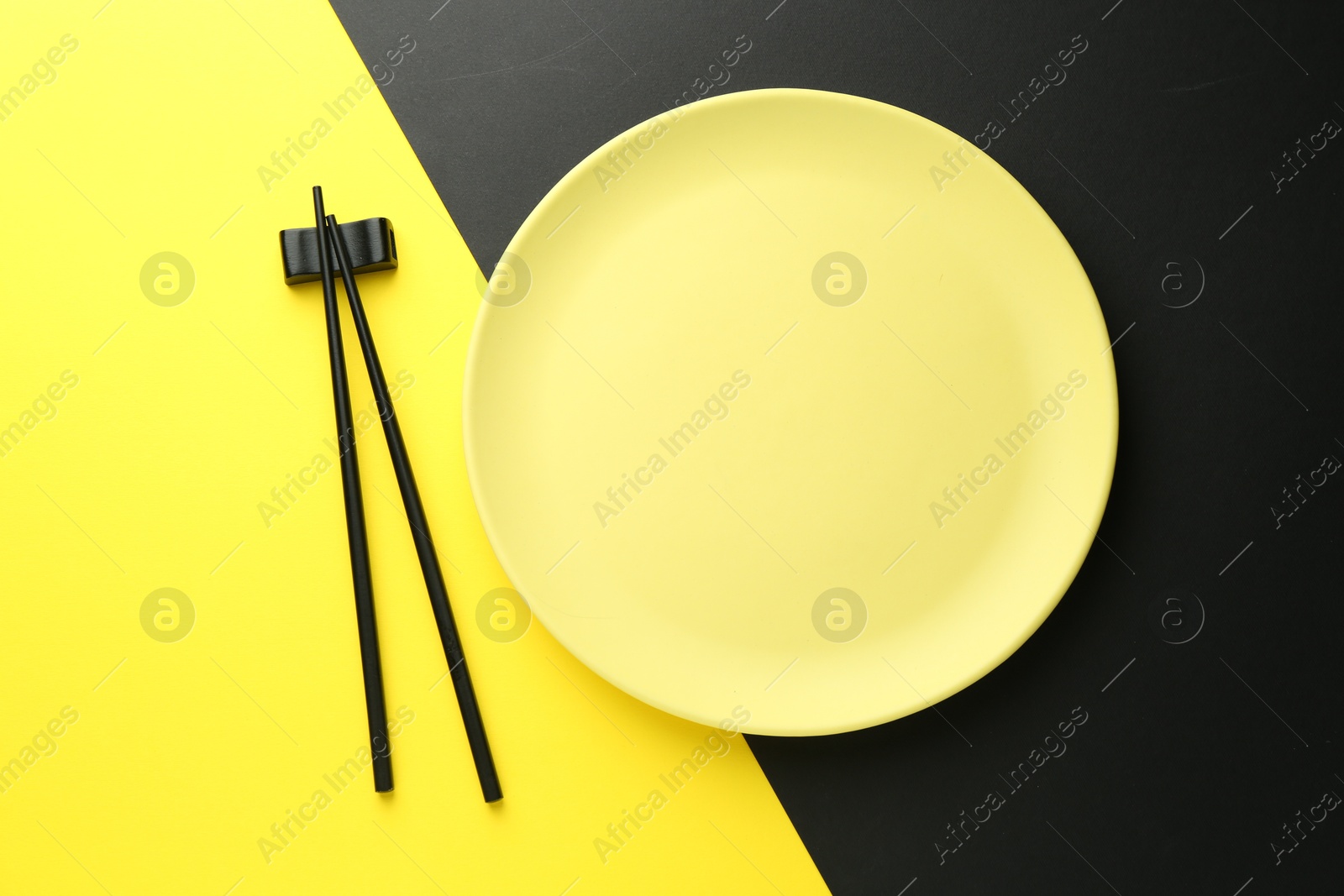 Stylish plate and chopsticks on color background, flat lay Photo of Stylish plate and chopsticks on color background, flat lay