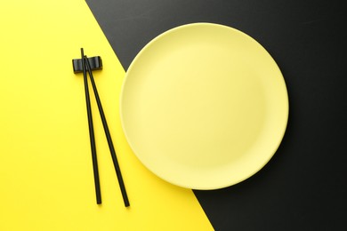 Photo of Stylish plate and chopsticks on color background, flat lay