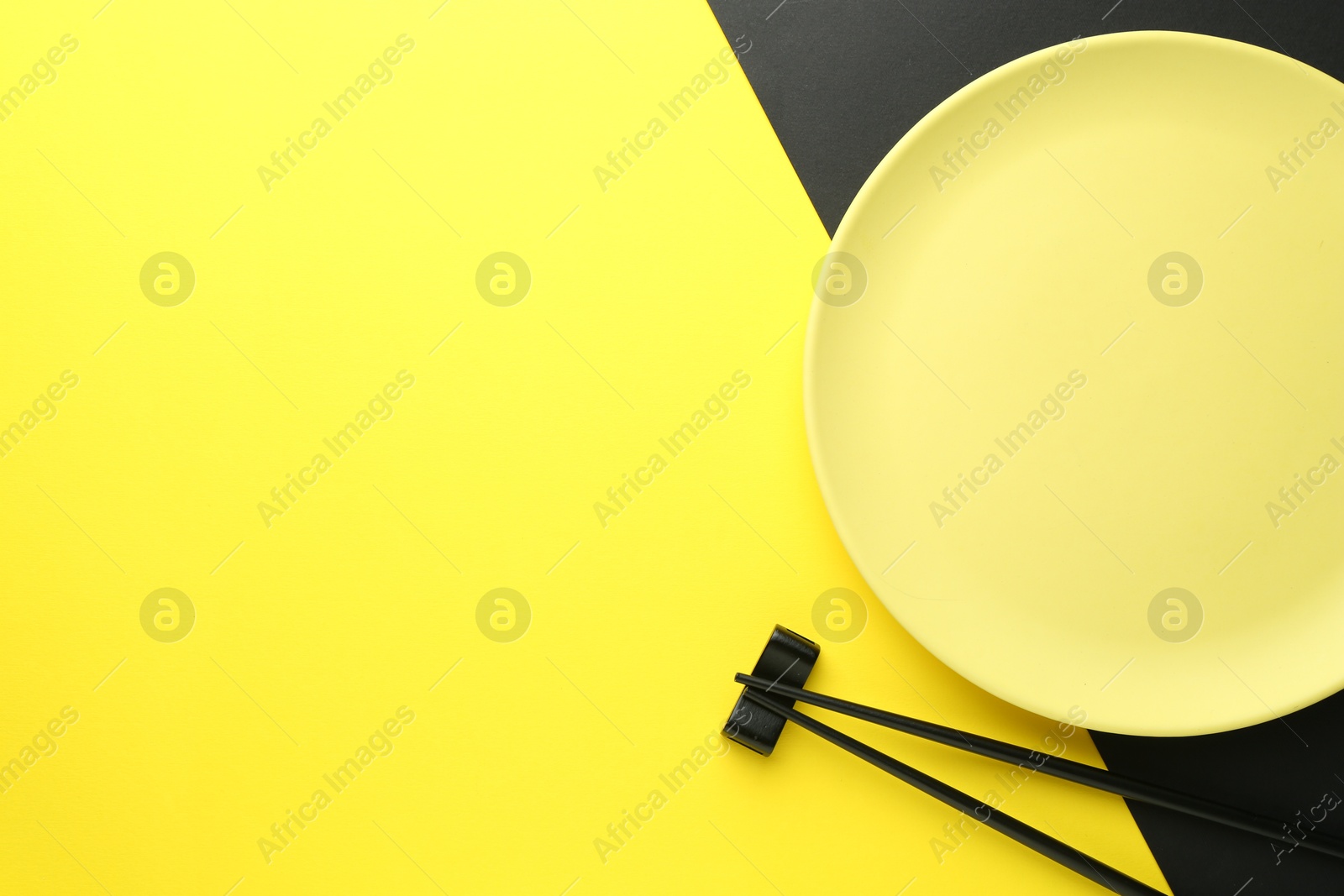 Stylish plate and chopsticks on color background, flat lay. Space for text Photo of Stylish plate and chopsticks on color background, flat lay. Space for text