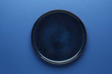 Photo of One stylish plate on blue background, top view