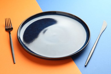 Photo of Stylish plate and cutlery on color background, closeup