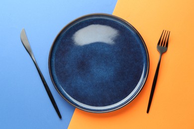 Photo of Stylish plate and cutlery on color background, flat lay