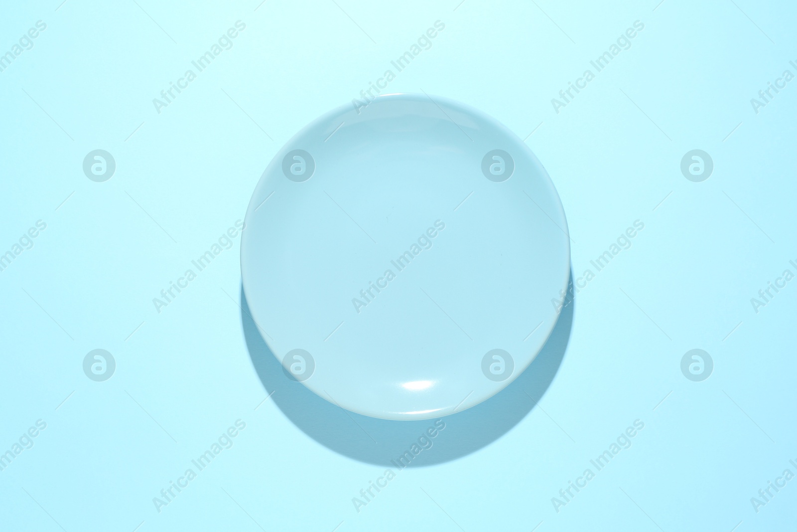 One stylish plate on light blue background, top view Photo of One stylish plate on light blue background, top view