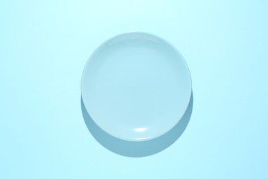Photo of One stylish plate on light blue background, top view