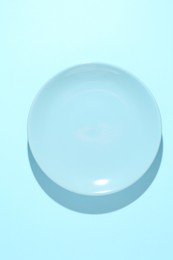 Photo of One stylish plate on light blue background, top view