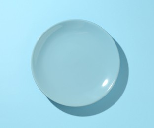 Photo of One stylish plate on light blue background, top view