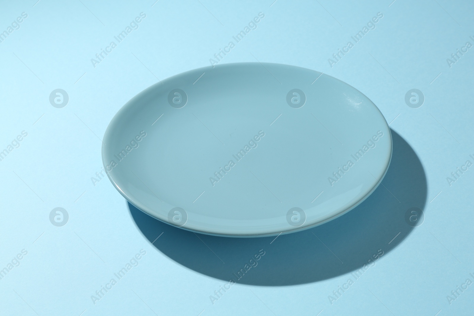 One stylish plate on light blue background, closeup Photo of One stylish plate on light blue background, closeup