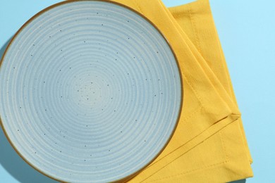 Photo of Stylish plate and napkin on light blue background, top view