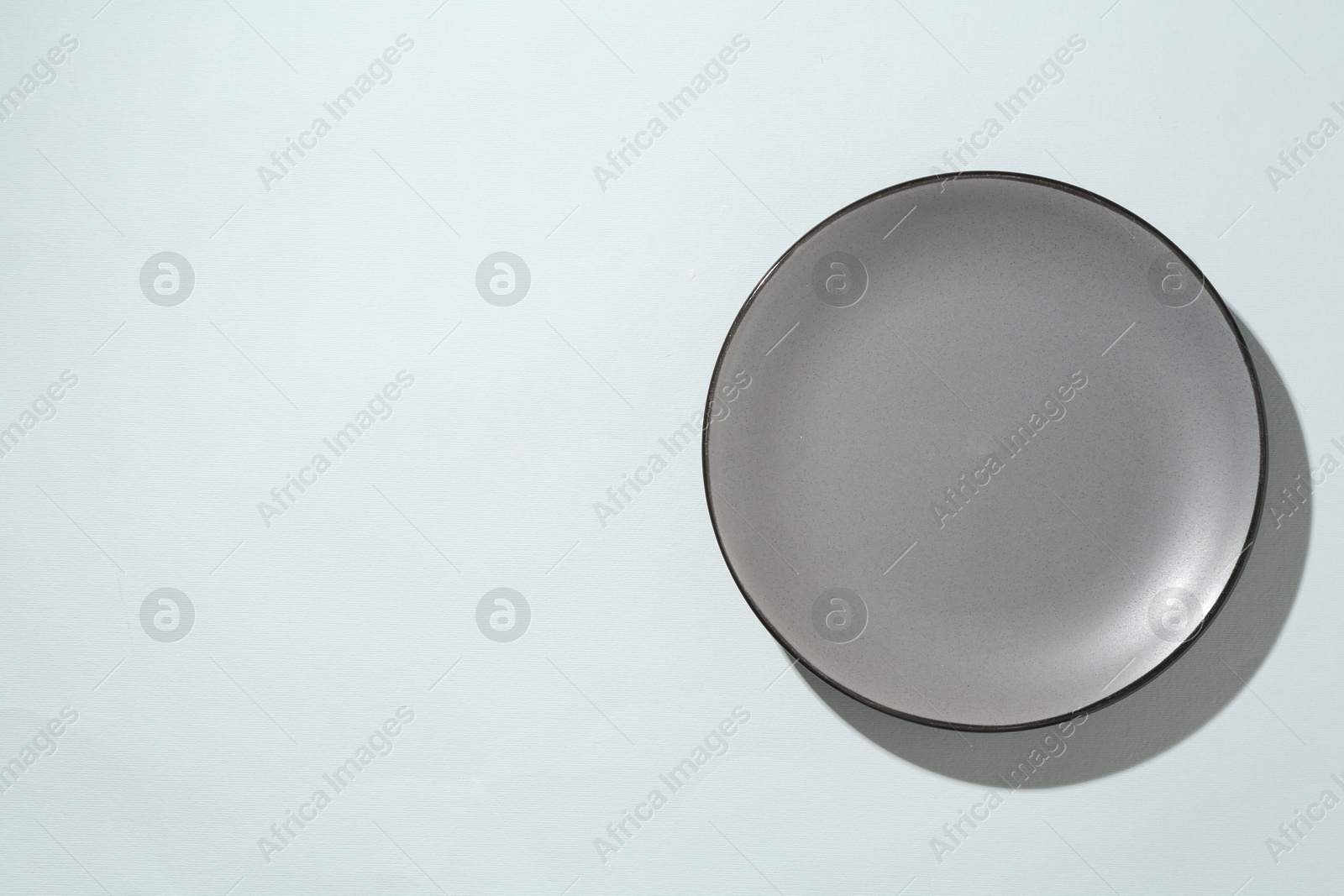 One stylish plate on white background, top view. Space for text Photo of One stylish plate on white background, top view. Space for text