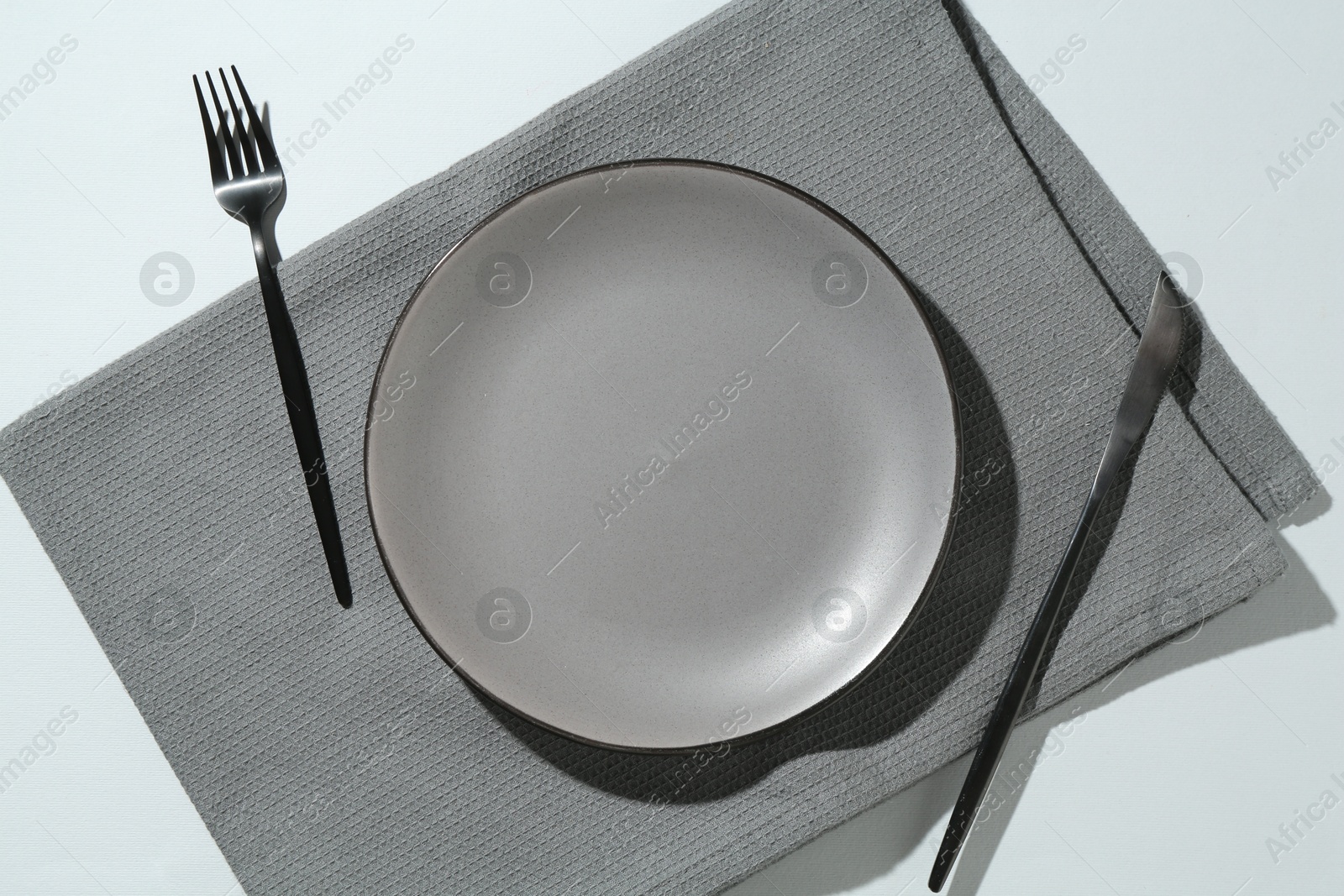 Stylish plate, cutlery and napkin on white background, flat lay Photo of Stylish plate, cutlery and napkin on white background, flat lay