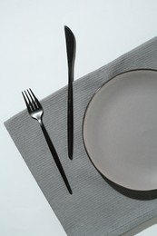 Photo of Stylish plate, cutlery and napkin on white background, flat lay