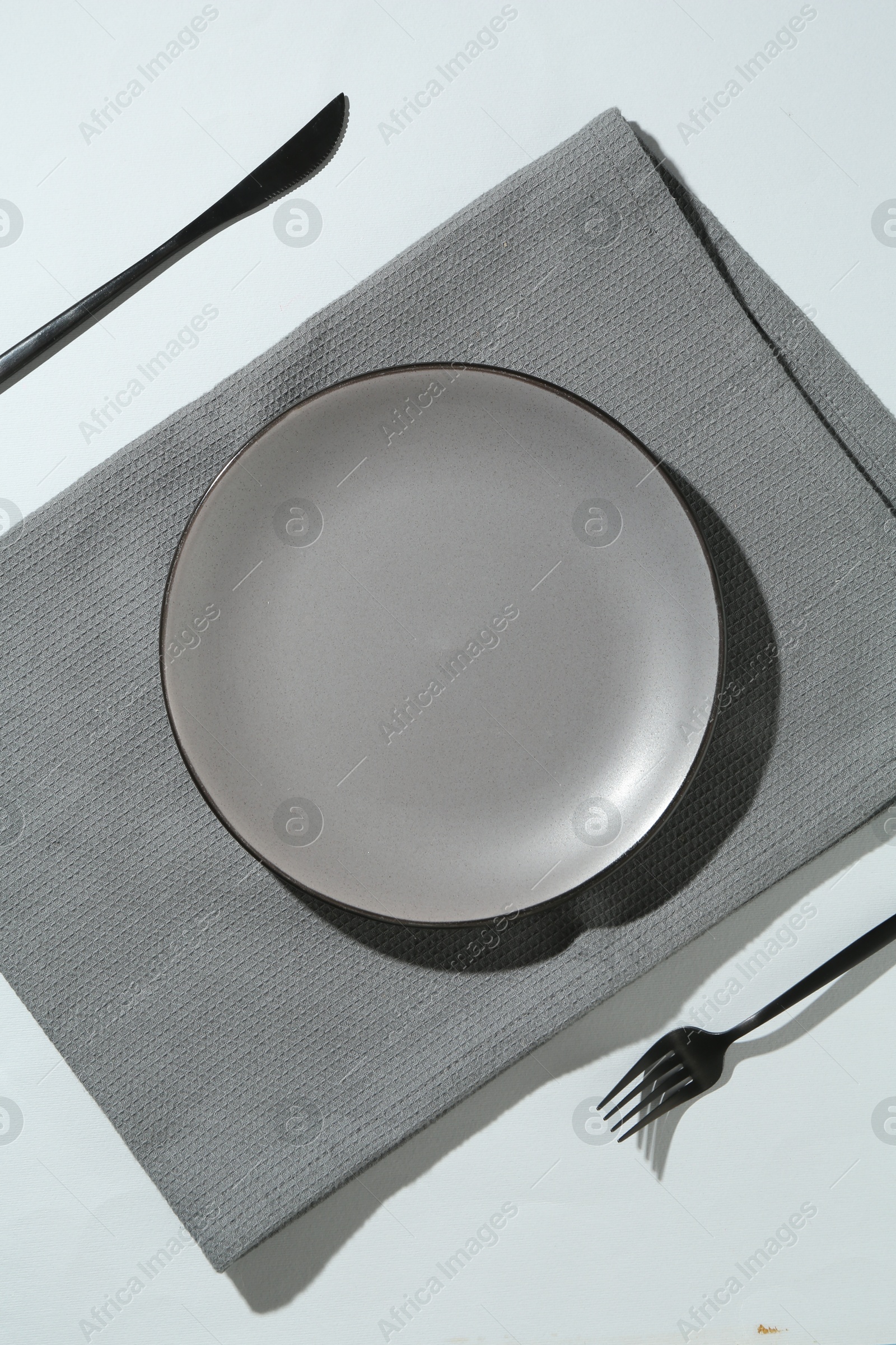 Stylish plate, cutlery and napkin on white background, flat lay Photo of Stylish plate, cutlery and napkin on white background, flat lay