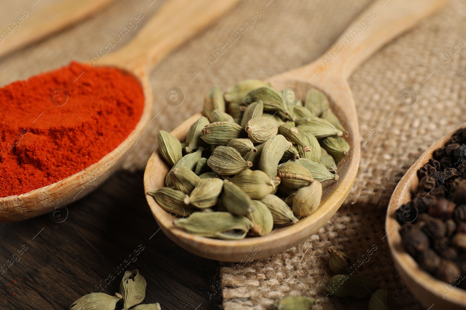 Photo of Different aromatic spices in spoons on table, closeup