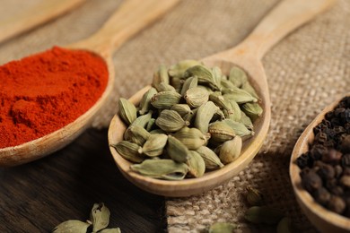Photo of Different aromatic spices in spoons on table, closeup
