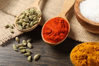 Photo of Different aromatic spices on wooden table, closeup