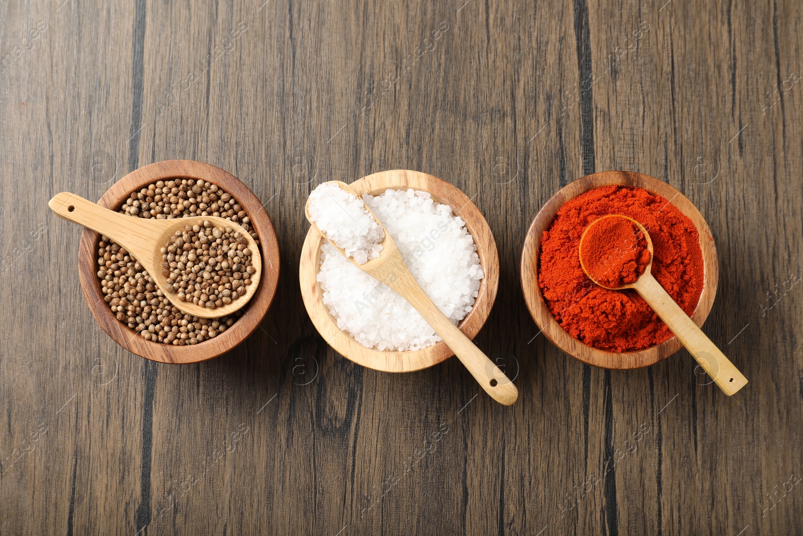 Photo of Different aromatic spices on wooden table, flat lay