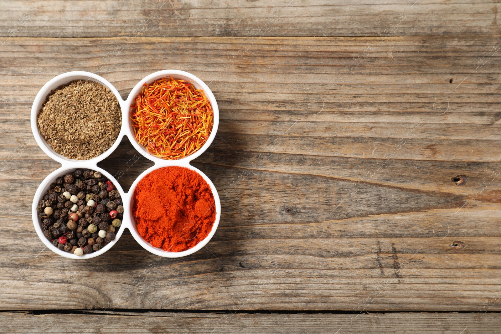 Photo of Different aromatic spices on wooden table, flat lay. Space for text