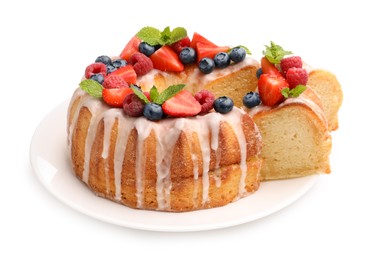 Photo of Delicious bundt cake with berries, glaze and mint isolated on white
