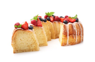 Photo of Pieces of delicious bundt cake with berries, glaze and mint isolated on white