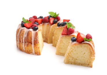 Photo of Pieces of delicious bundt cake with berries, glaze and mint isolated on white