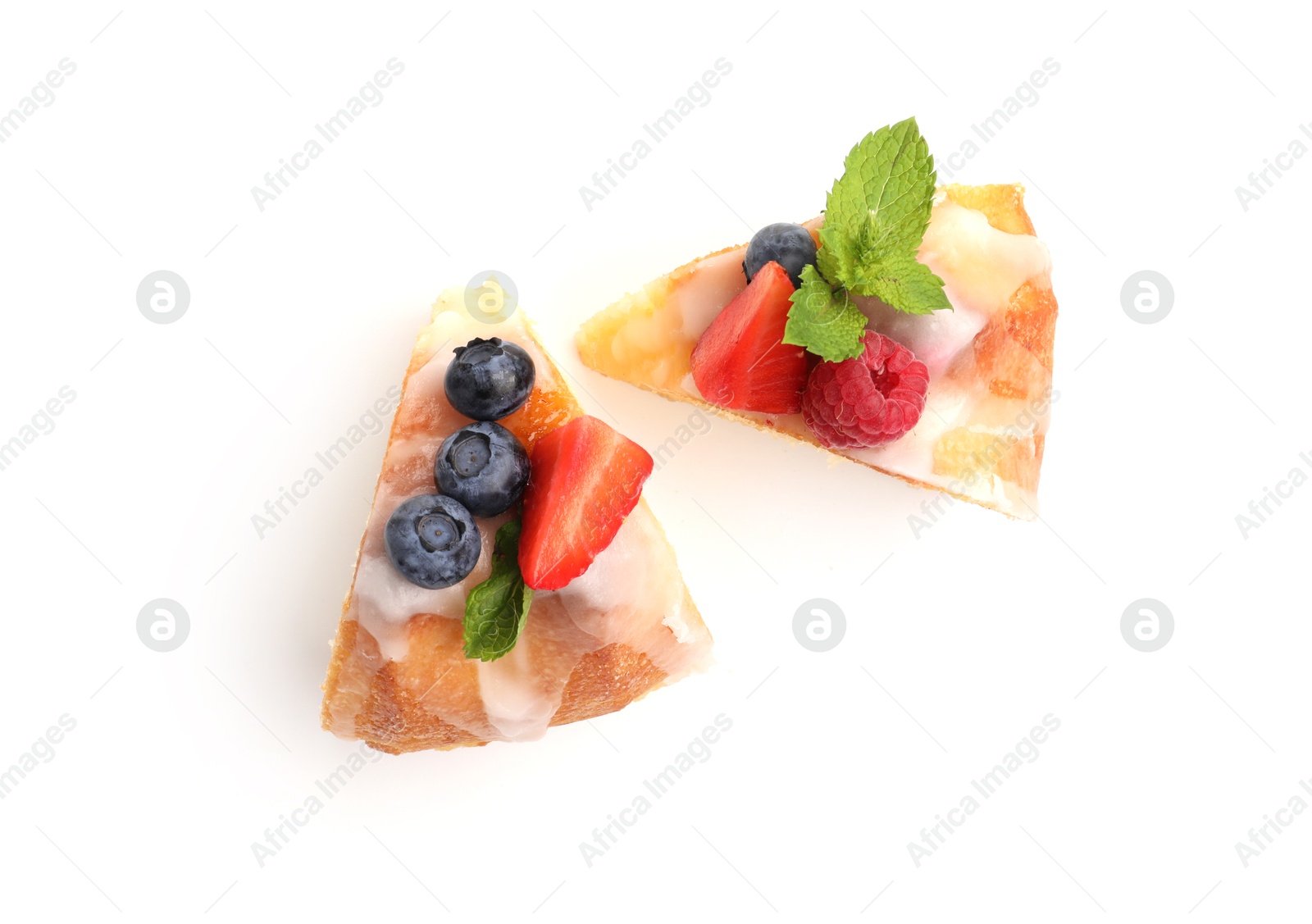 Pieces of delicious bundt cake with berries, glaze and mint isolated on white, top view Photo of Pieces of delicious bundt cake with berries, glaze and mint isolated on white, top view