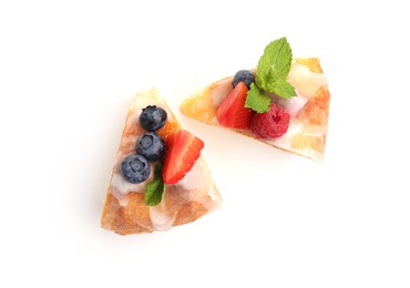 Photo of Pieces of delicious bundt cake with berries, glaze and mint isolated on white, top view
