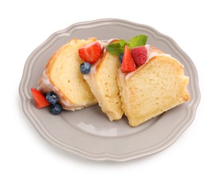 Photo of Pieces of delicious bundt cake with berries, glaze and mint isolated on white