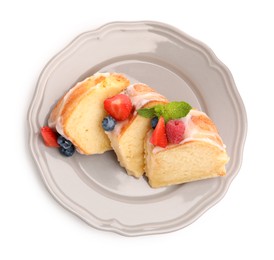 Photo of Pieces of delicious bundt cake with berries, glaze and mint isolated on white, top view
