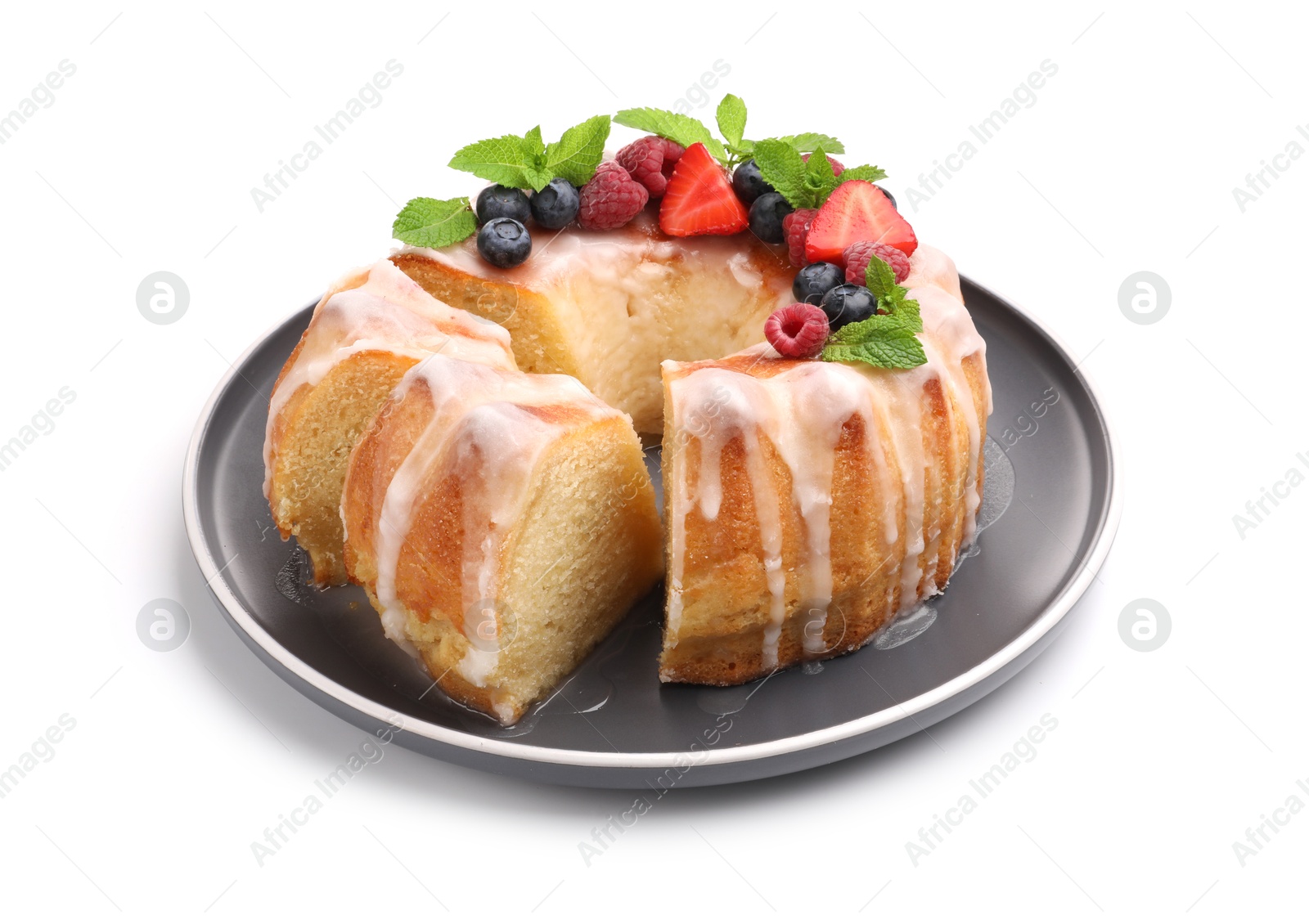 Photo of Pieces of delicious bundt cake with berries, glaze and mint isolated on white