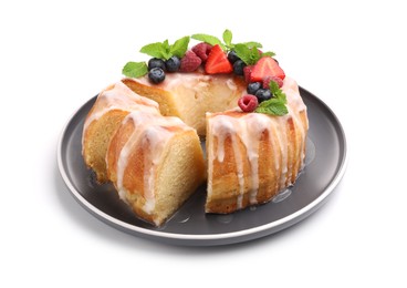 Photo of Pieces of delicious bundt cake with berries, glaze and mint isolated on white