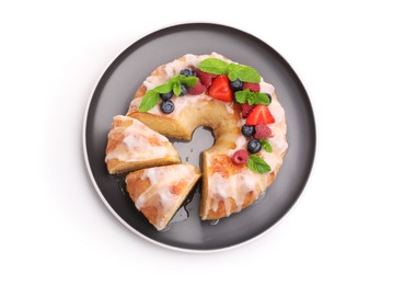 Photo of Pieces of delicious bundt cake with berries, glaze and mint isolated on white, top view