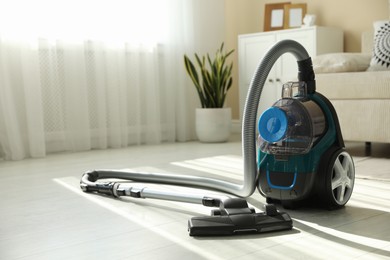 Photo of One vacuum cleaner on floor indoors. Household appliance