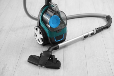 Photo of One vacuum cleaner on wooden floor. Household appliance